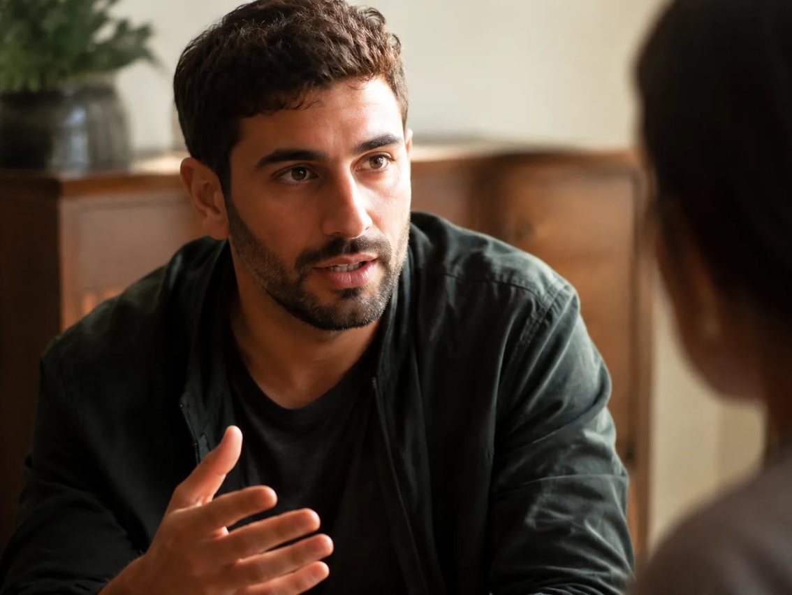 Participante de pé diante do grupo sustentando um ponto com as anotações na mão